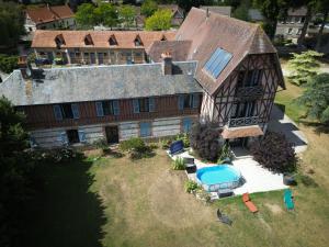 an aerial view of a large house with a swimming pool at Caux Loc' du Manoir in Graincourt