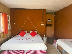a bedroom with two beds with red pillows at Nilamane in Asilah