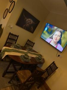 a room with a table and a tv on the wall at The Loft in Nantgaredig