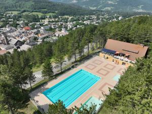 an overhead view of a large swimming pool with a city at Le cocon de Barcelonnette in Barcelonnette