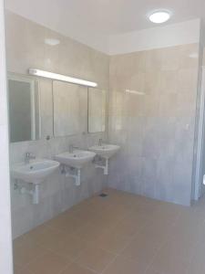 a bathroom with two sinks and two mirrors at Relax Camp Pitches in Pakoštane