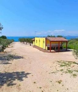 a building on a dirt road next to a field at Relax Camp Pitches in Pakoštane +24 photos