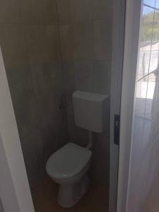 a small bathroom with a toilet and a window at Relax Camp Pitches in Pakoštane