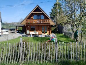 a wooden house with a fence in front of it at Blockbohlenhaus-Steiner-Lodge in Steinen