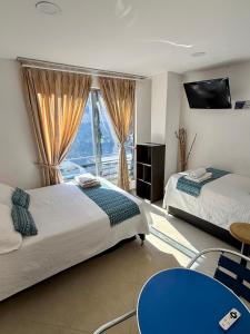 a bedroom with two beds and a large window at Living Montes in Medellín