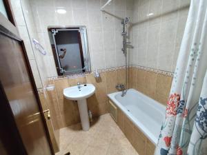 a bathroom with a sink and a toilet and a tub at La Luna Rentals in Asilah