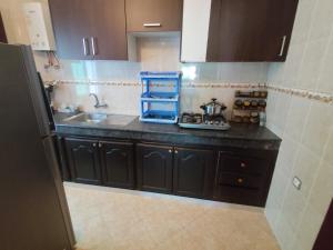 a kitchen with black cabinets and a counter top at La Luna Rentals in Asilah