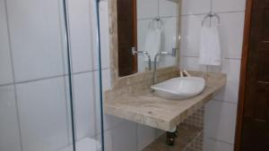 a bathroom with a sink and a glass shower at Trancoso Casas Para Temporada in Trancoso +34 photos