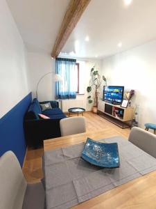 a living room with a couch and a tv at Nids des cigognes in Furchhausen