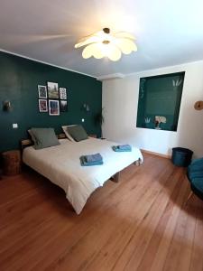 a bedroom with a large bed and a green wall at Nids des cigognes in Furchhausen
