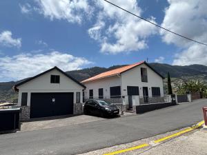 a car parked in front of a white house at Tina's Place in Machico