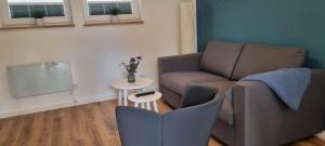 a living room with a couch and a table at Ferienhaus Wellenklang in Glowe