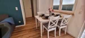 a white dining room table and chairs in a room at Ferienhaus Wellenklang in Glowe