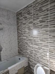 a bathroom with a bath tub and a toilet at Le gite 2 in Libreville
