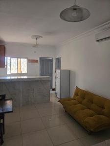 a living room with a couch and a kitchen at Le gite 2 in Libreville