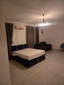 a small bedroom with a bed and a couch at Le gite 2 in Libreville