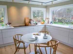 a kitchen with a white table and chairs and two windows at Valberg Gjestegård in Valberg +63 photos