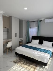 a bedroom with a large bed and a desk at Gabstel Apartments in Kitwe
