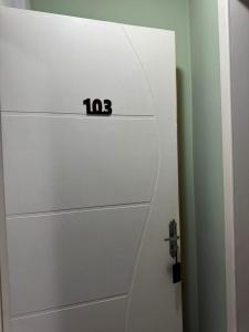 a white garage door with the number on it at Hotel Guerra - Pousada Montebelo in Jaguaruna