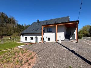 a white house with a garage and a driveway at Alpine Chalet Krkonose in Prosečné