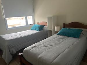 a bedroom with two beds and a window at Coty A in Saladillo