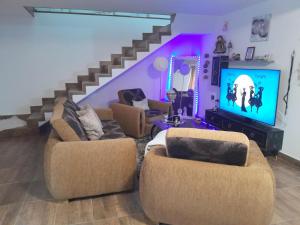 a living room with two chairs and a flat screen tv at Casa Maria in Curtea de Argeş