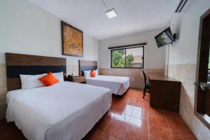 ein Hotelzimmer mit zwei Betten und einem Fernseher in der Unterkunft Nuve Express Abasolo in Torreón