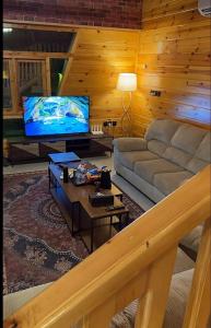 a living room with a couch and a flat screen tv at اكواخ لاكجري ابها 2 in Abha