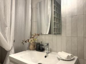 a white bathroom with a sink and a mirror at Central Park View Apartment in Dobrich