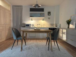 a kitchen with a wooden table and two chairs at Central Park View Apartment in Dobrich