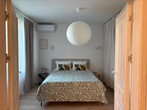 a bedroom with a bed and a pendant light at Central Park View Apartment in Dobrich