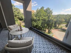 a balcony with a table and chairs and a large window at Central Park View Apartment in Dobrich