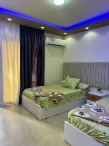 a bedroom with two beds and a blue ceiling at Adel Apartments at alkarma resorts& aquapark in Hurghada +174 photos