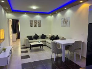 a living room with a couch and a table at Adel Apartments at alkarma resorts& aquapark in Hurghada