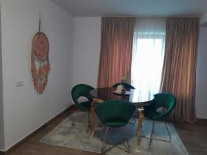 a dining room with a table and green chairs at Casa Maria in Curtea de Argeş