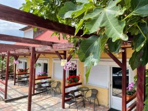 a patio with tables and chairs under a pergola at Gábor Magánszállás Nagykanizsa Alkotmány út 195 in Palin