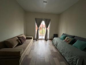 a living room with a couch and a large window at Coty A in Saladillo