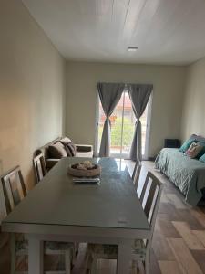 a dining room with a table and a bed at Coty A in Saladillo