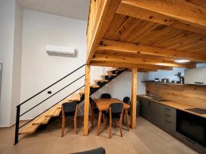 a kitchen with a wooden table and a staircase at RiverMount Hotel Borsh in Borsh