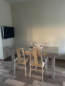 a dining room table with four chairs and a television at Coty A in Saladillo