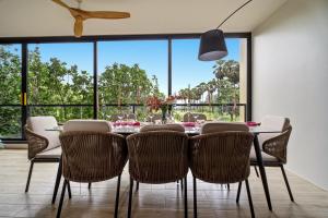a dining room with a table and chairs and a large window at Seashore Beach Residences by NLA in Bang Tao Beach +35 photos