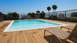 a swimming pool with a chair and a bench on a deck at Azura Boutique Hotel Tiberias in Tiberias