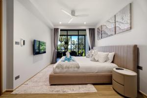a bedroom with a large bed and a window at Seashore Beach Residences by NLA in Bang Tao Beach