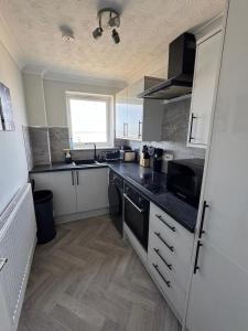 a kitchen with a black counter top in a room at Sea-View Luxury Apartment sleeps 5 - Pet Friendly - Fast WiFi - Off Street Parking - Contractors Dream!!! in Sheerness