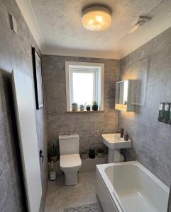 a bathroom with a tub and a toilet and a sink at Sea-View Luxury Apartment sleeps 5 - Pet Friendly - Fast WiFi - Off Street Parking - Contractors Dream!!! in Sheerness
