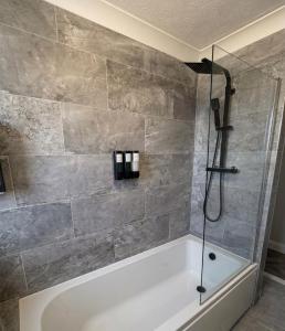 a bathroom with a tub and a shower at Sea-View Luxury Apartment sleeps 5 - Pet Friendly - Fast WiFi - Off Street Parking - Contractors Dream!!! in Sheerness