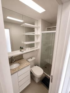 a white bathroom with a toilet and a sink at Apt Premium com Vista Panorâmica e Lazer Completo in Joinville +4 photos