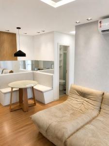 a living room with a couch and a table at Apt Premium com Vista Panorâmica e Lazer Completo in Joinville
