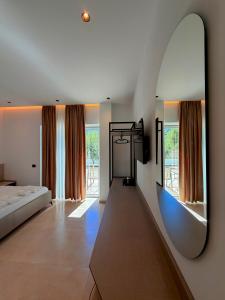 a bedroom with a bed and a mirror on the wall at RiverMount Hotel Borsh in Borsh