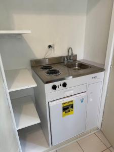 a small kitchen with a stove and a sink at O E Liburd Residence in Charlestown